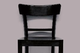 schwarzer Stuhl vor grauem Hintergrund